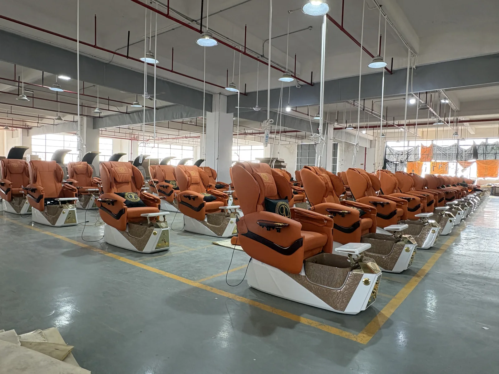 Rows of assembled Corona4Salon pedicure chairs in the production workshop